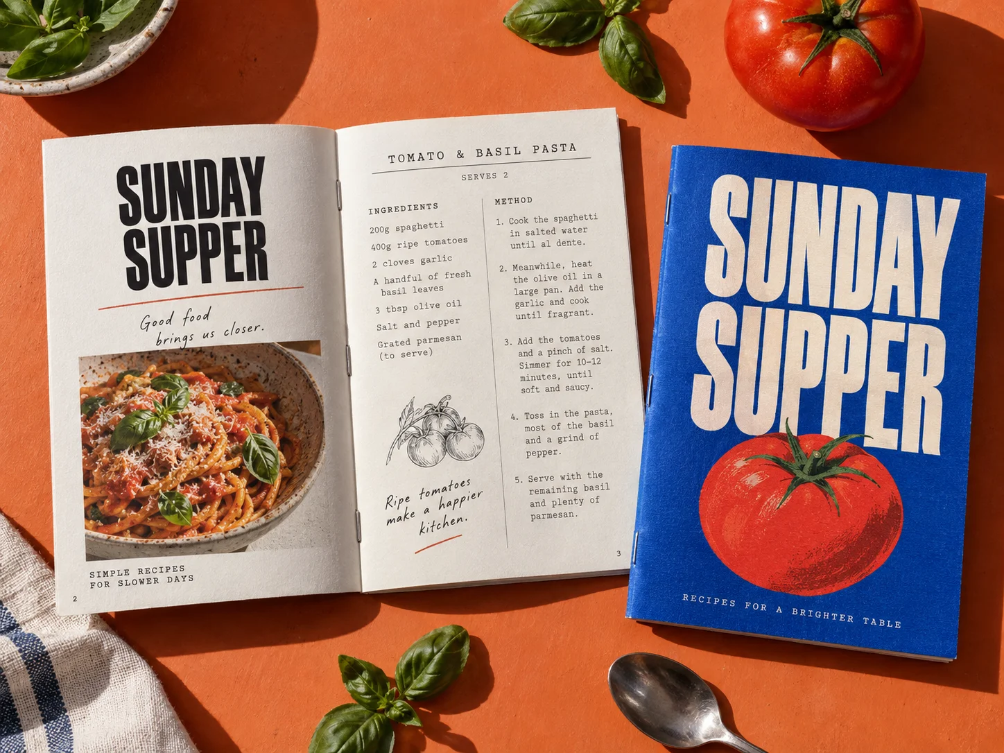 A handmade Sunday Supper recipe zine with a blue cover on an orange worktop